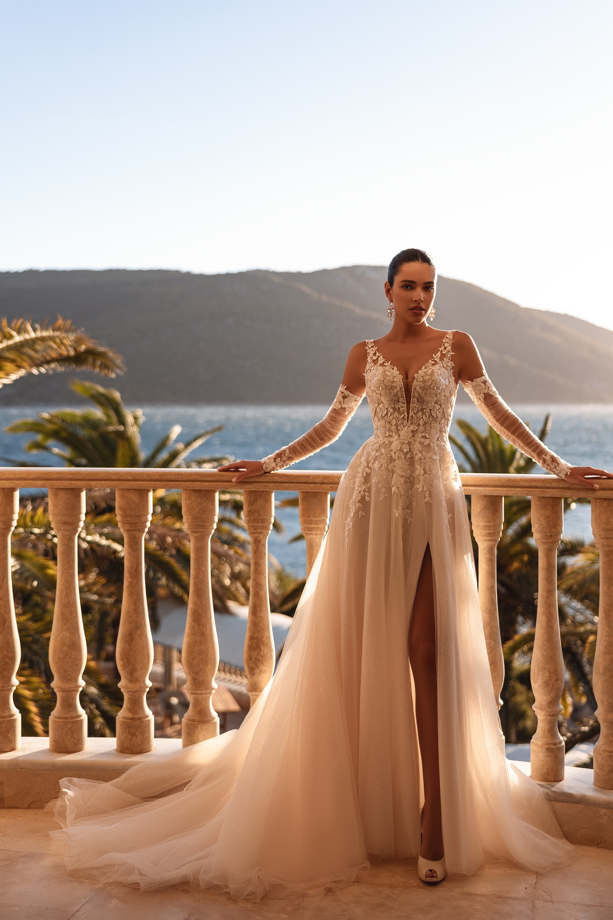 A-lijn trouwjurk met split Cosmobella 8279. Vooraanzicht van de jurk met kanten V-hals en afneembare mouwen van tule.