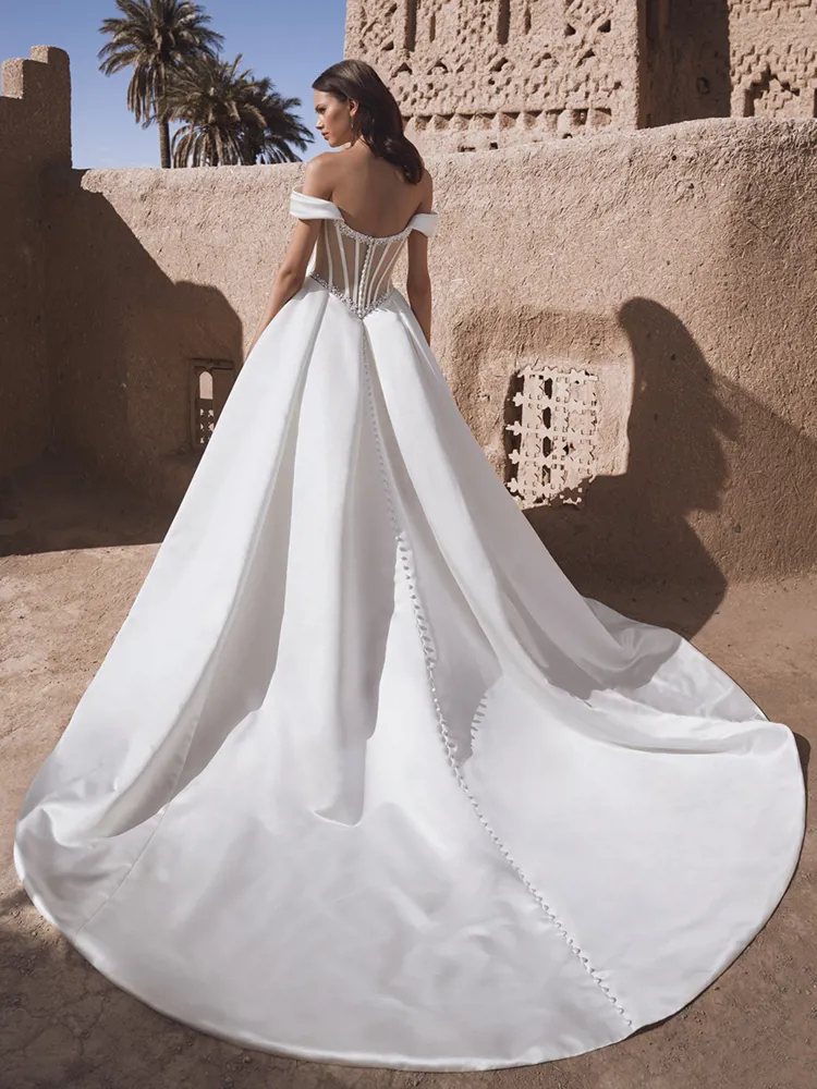 Trouwjurk Temina met lage rug van Blue by Enzoani. Achteraanzicht met see-through korset en lange satijnen sleep met knoopjes.
