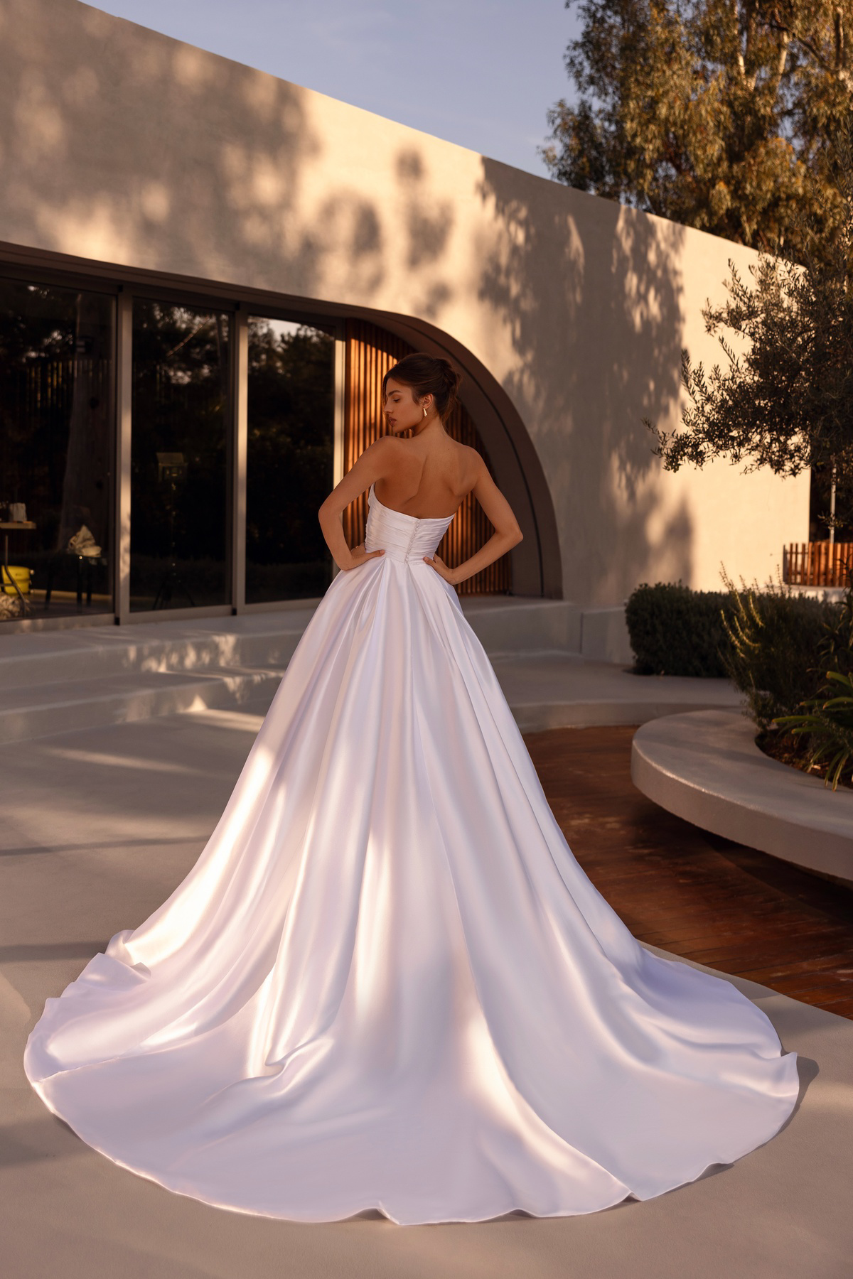 Satijnen prinsessenjurk 1525 Demetrios met lange sleep. Achteraanzicht van het strapless, gedrapeerde lijfje.