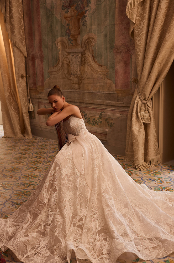 Strapless A-lijn trouwjurk Octavianna van Aria met een wijde rok met bladmotief en een strik in de taille. Vooraanzicht.