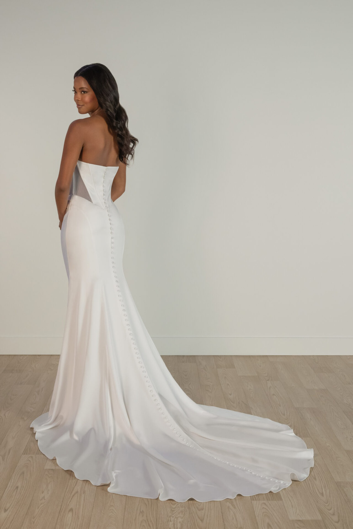 Achteraanzicht aangesloten trouwjurk 8161 Stella York met see-through korsetlijfje en lange sleep met picpac knoopjes.