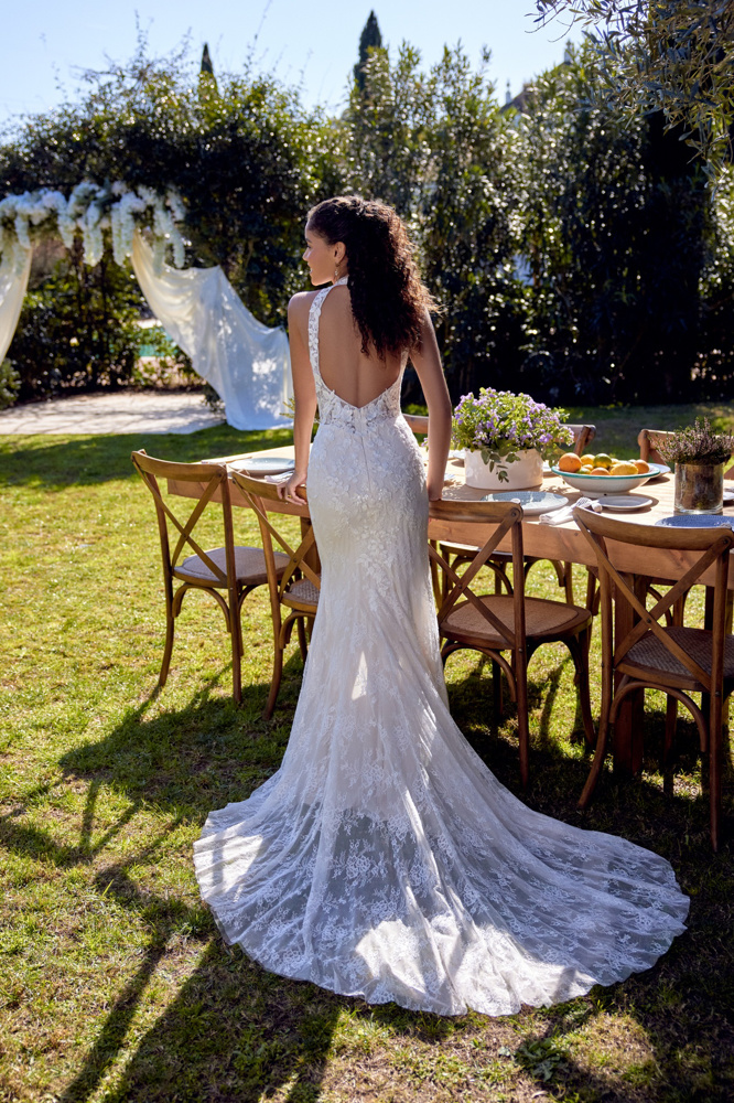 Trouwjurk met lage rug 66424 van Lillian West. Achteraanzicht van de aangesloten kanten jurk met halter en sleep.