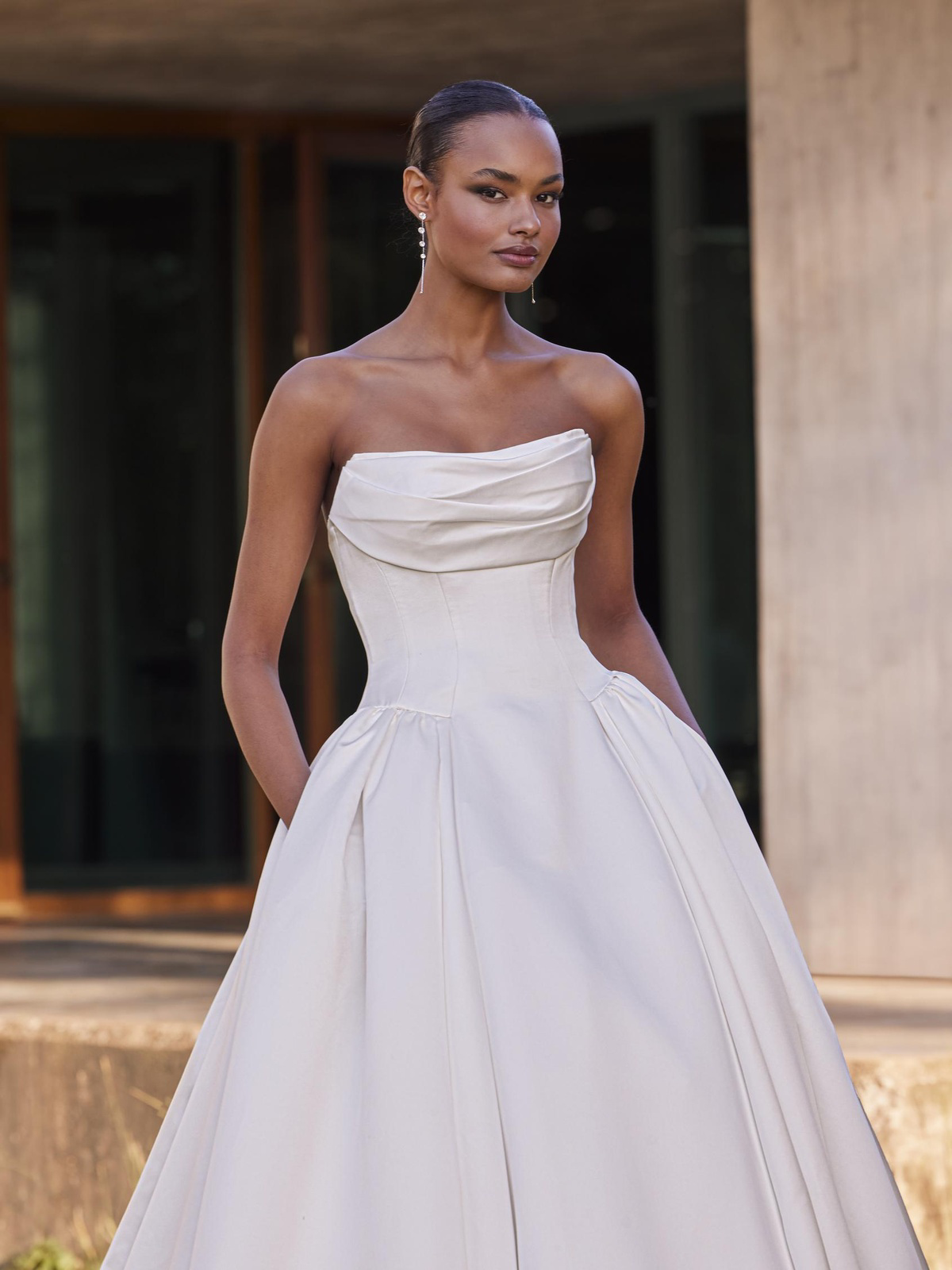 Strapless trouwjurk Cillian van Pronovias. Close-up van het gedrapeerde lijfje met de satijnen prinsessenrok met zakken.