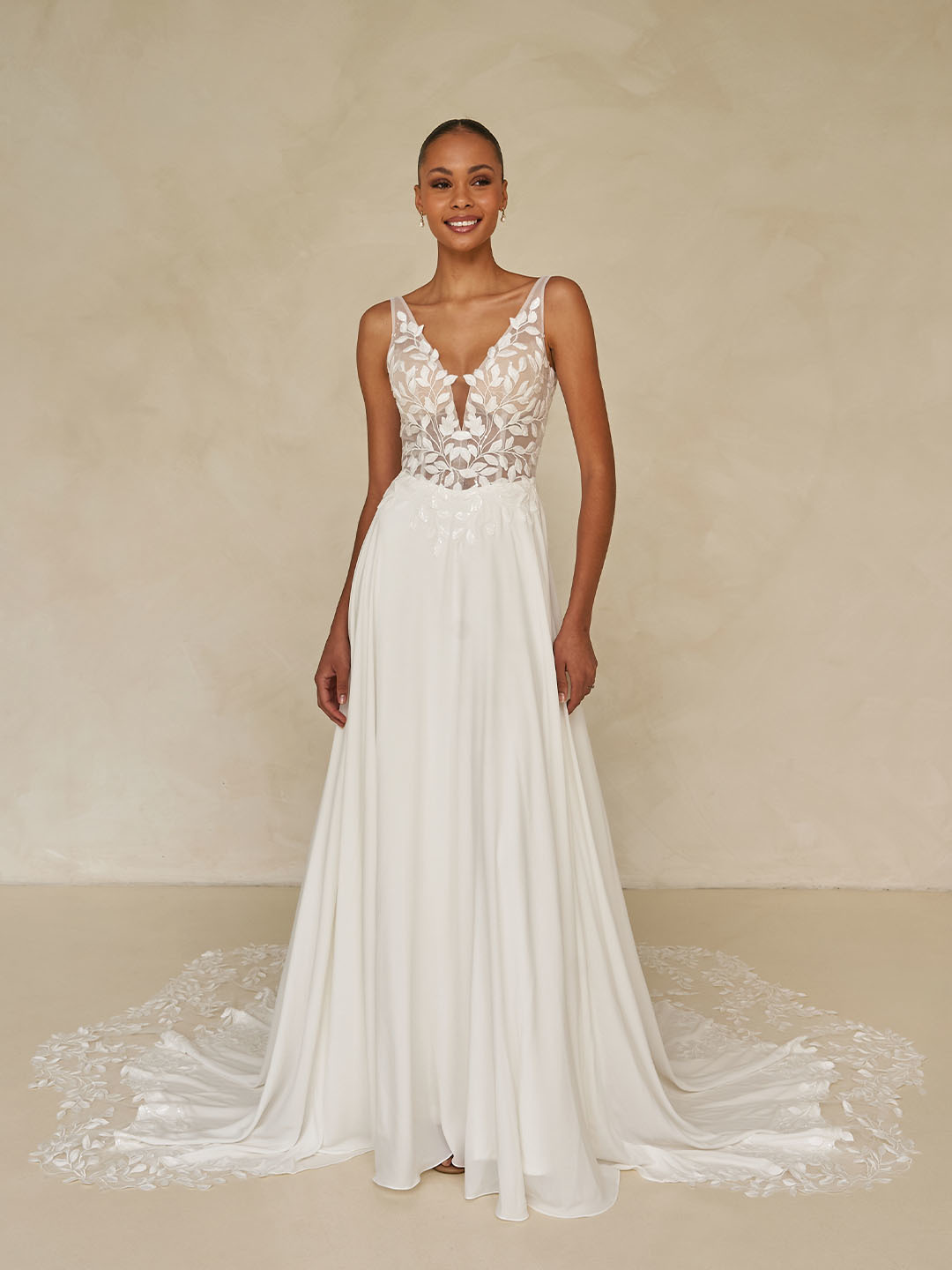 A-lijn trouwjurk Wilmott van Madi Lane met V-hals en see-through lijfje. Vooraanzicht van de flowy rok met kanten sleep.