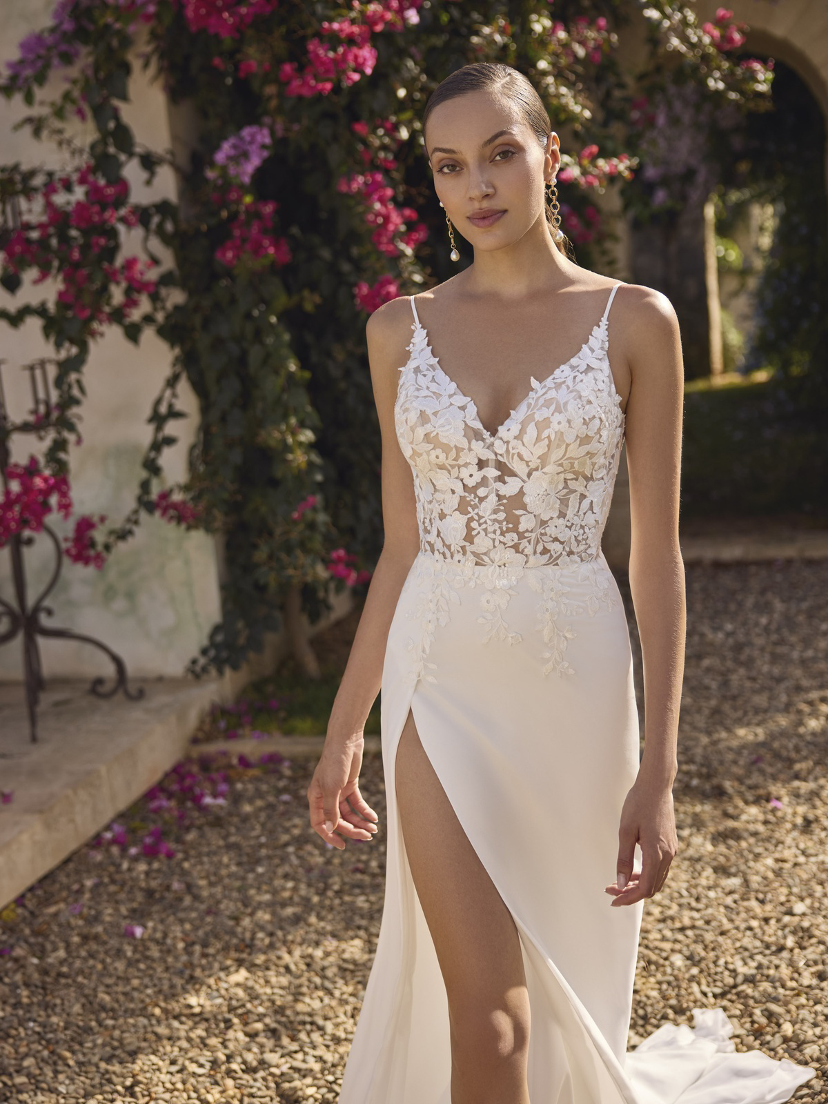 Trouwjurk met split Glamour van Modeca. Vooraanzicht van het see-through kanten lijfje met V-hals en gladde rok.