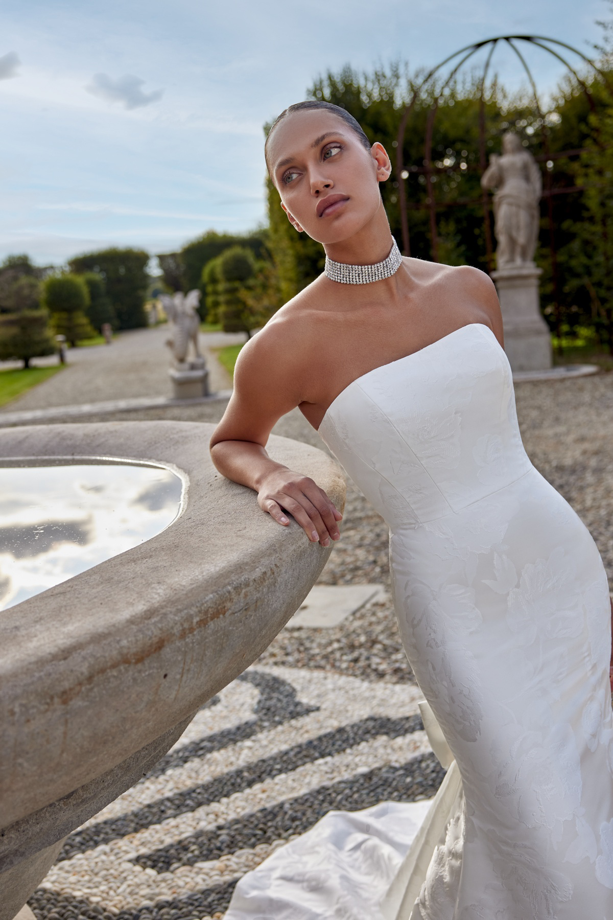 Strapless trouwjurk Kirsten van Justin Alexander. Zijaanzicht van het aangesloten model met luxe bloemenpatroon.