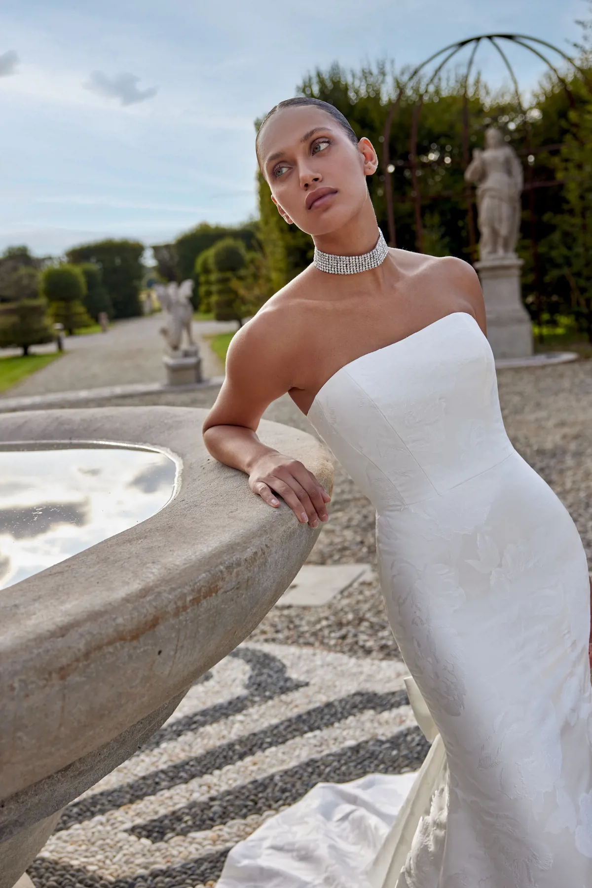 Strapless trouwjurk Kirsten van Justin Alexander. Zijaanzicht van het aangesloten model met luxe bloemenpatroon.
