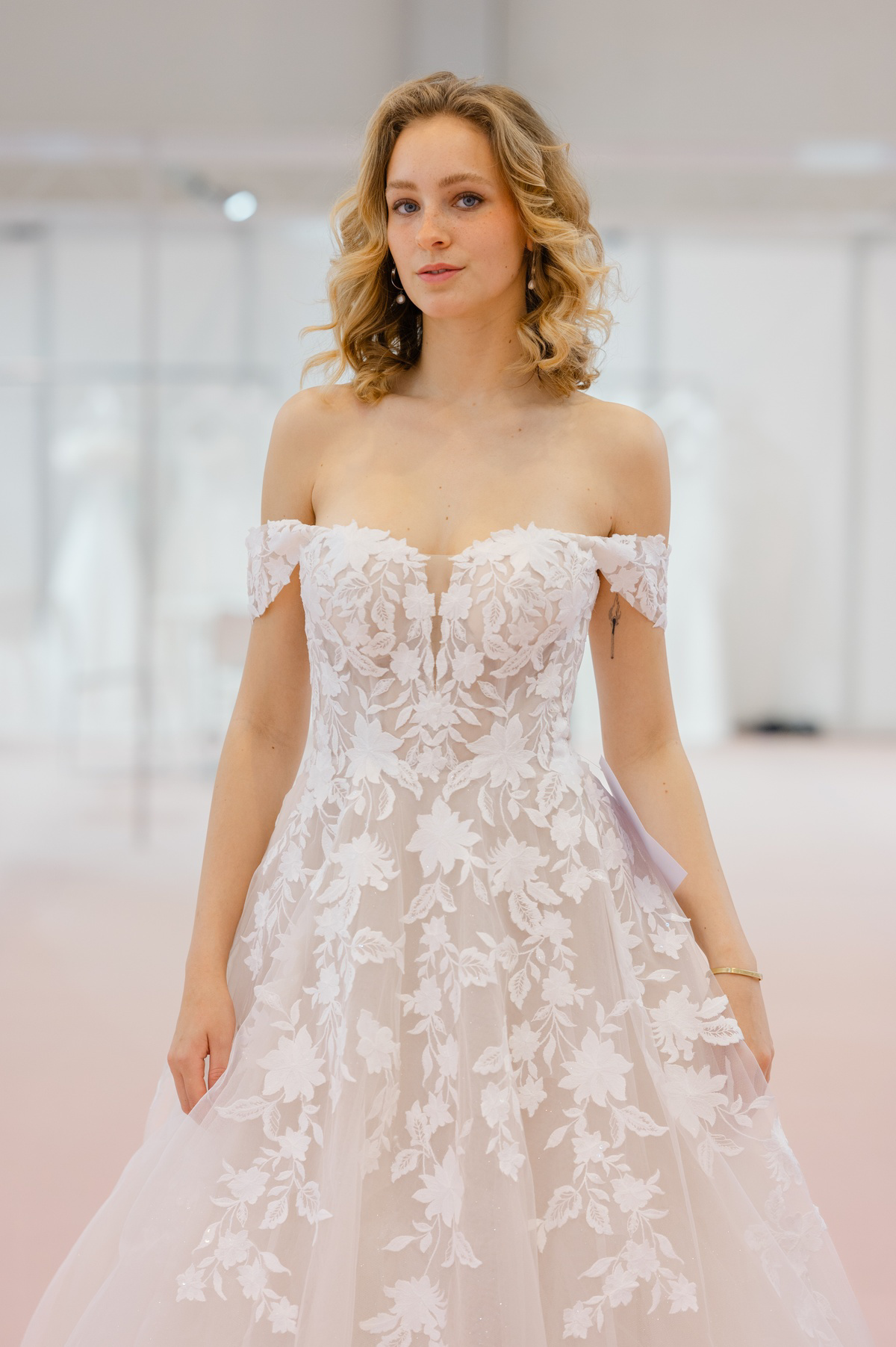 Off-shoulder A-lijn trouwjurk Deena van Azuree met 3D bloemenkant. Vooraanzicht van het romantische lijfje.