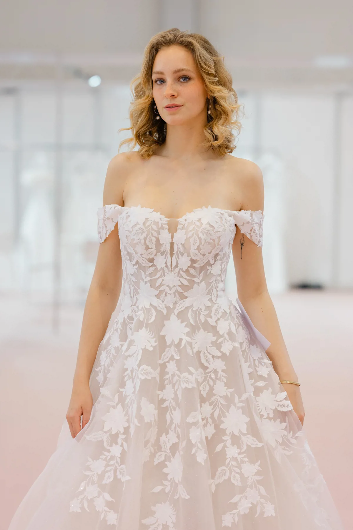 Off-shoulder A-lijn trouwjurk Deena van Azuree met 3D bloemenkant. Vooraanzicht van het romantische lijfje.