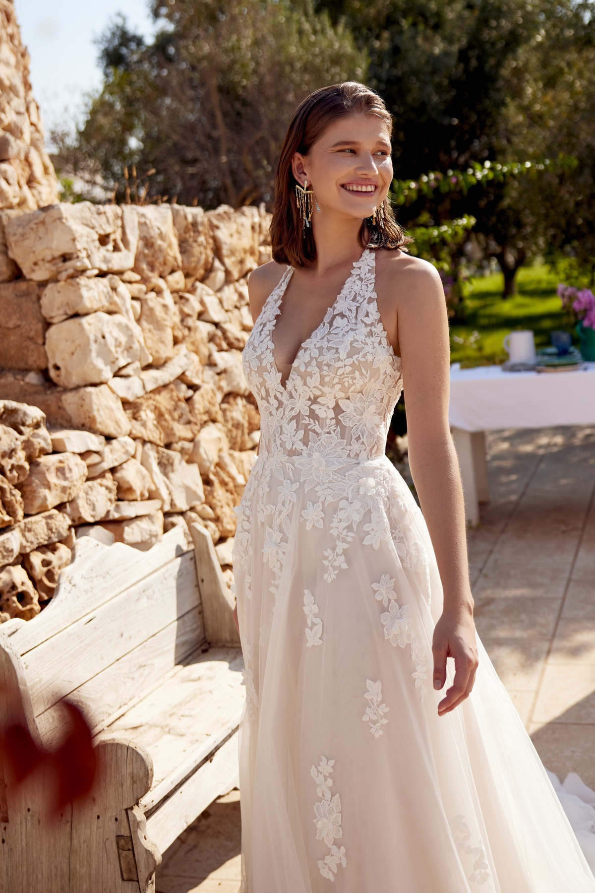A-lijn trouwjurk met kant 66405 van Lillian West. Zijaanzicht van de bohemian jurk met halter V-hals en bloemenapplicaties.