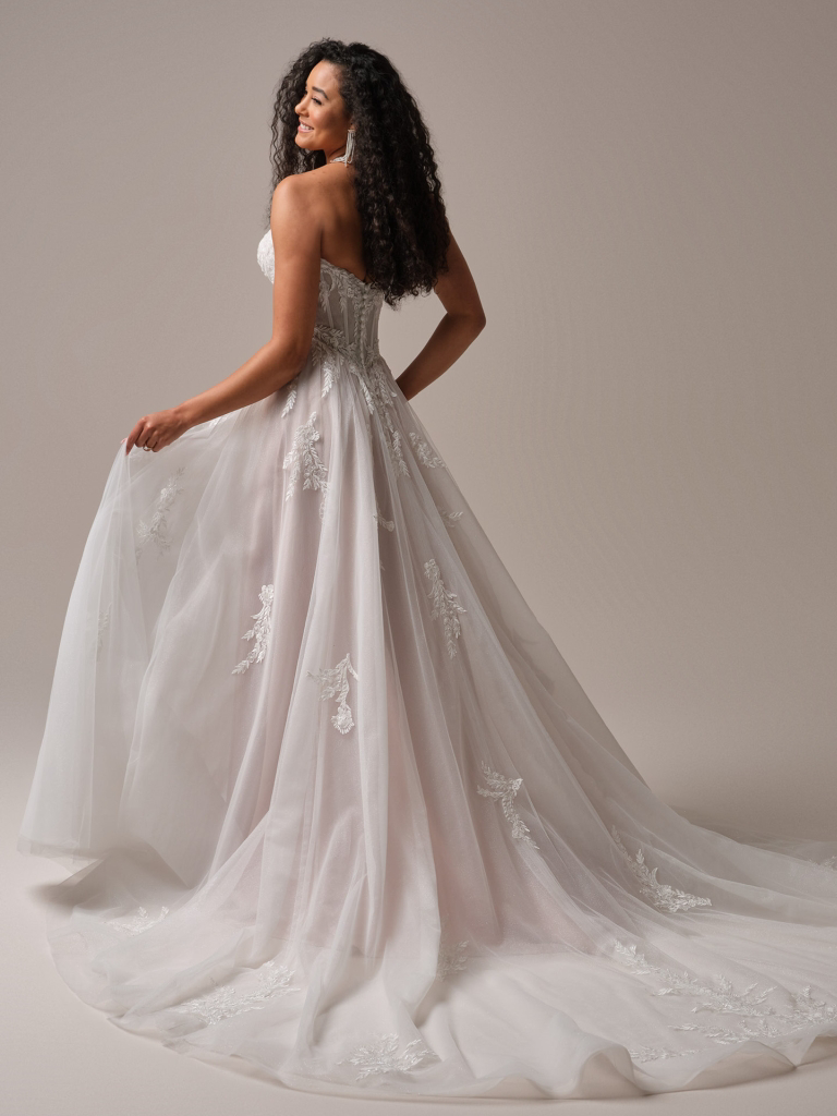 A-lijn trouwjurk Victoria van Maggie Sottero, achteraanzicht van het strapless korsetlijfje en de blush tule rok met kant.