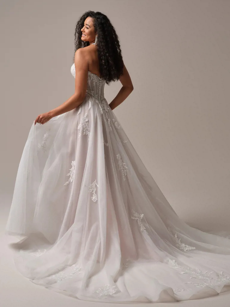 A-lijn trouwjurk Victoria van Maggie Sottero, achteraanzicht van het strapless korsetlijfje en de blush tule rok met kant.