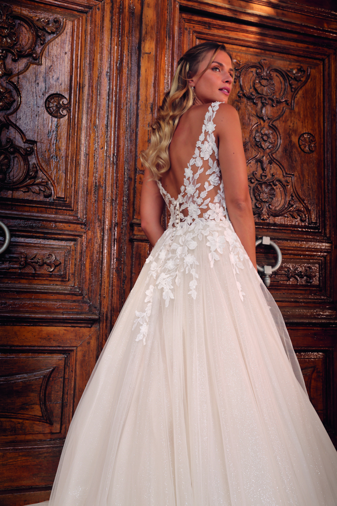 Trouwjurk met lage rug Arnolda van Azuree. Achteraanzicht van de kanten see-through rug en de wijde glitter tule rok.