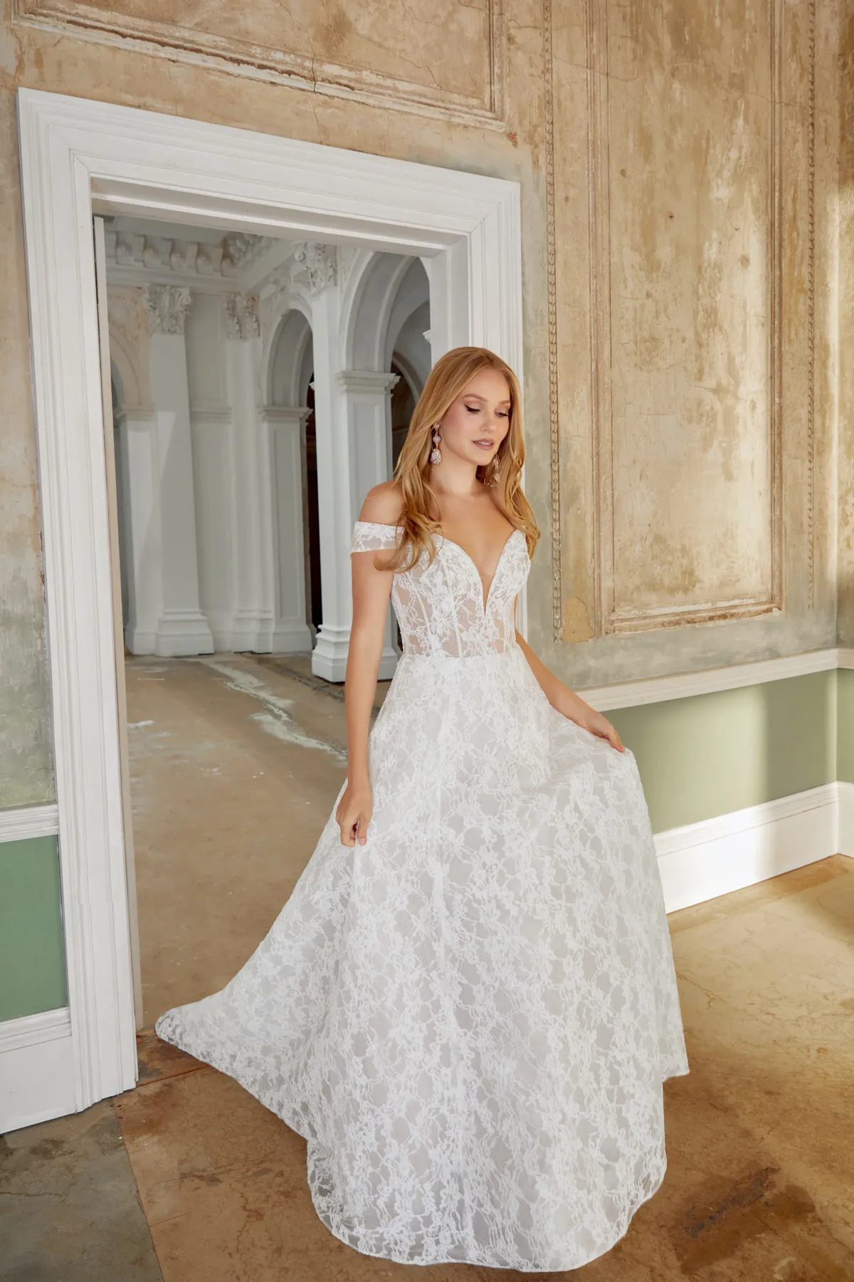A-lijn trouwjurk met kant 44541 van Sincerity Bridal. Vooraanzicht van het off-shoulder model met see-through lijfje.