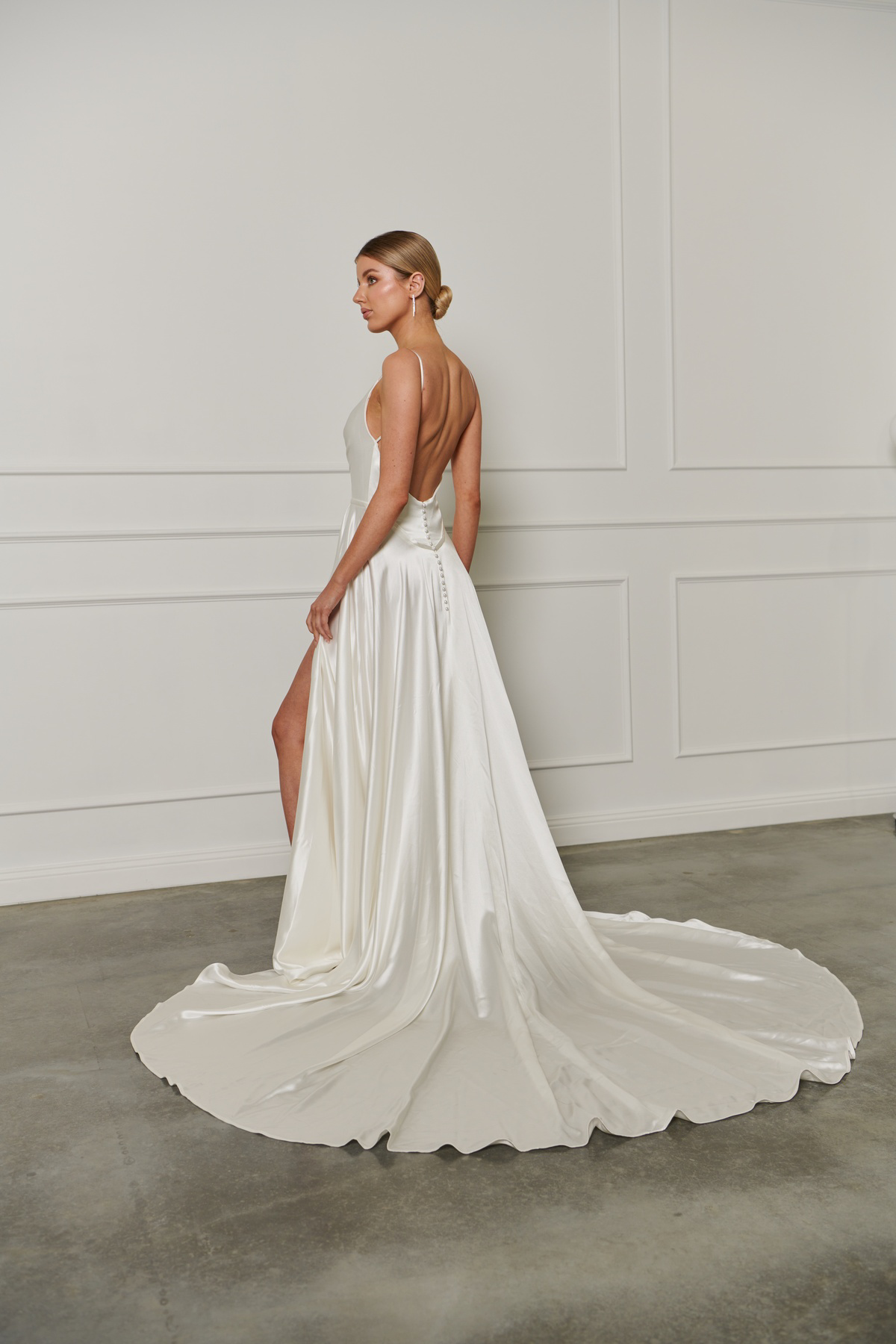 Satijnen trouwjurk 23207 van Cizzy Bridal met lage rug en split. Achteraanzicht van de A-lijn jurk met picpac knoopjes.