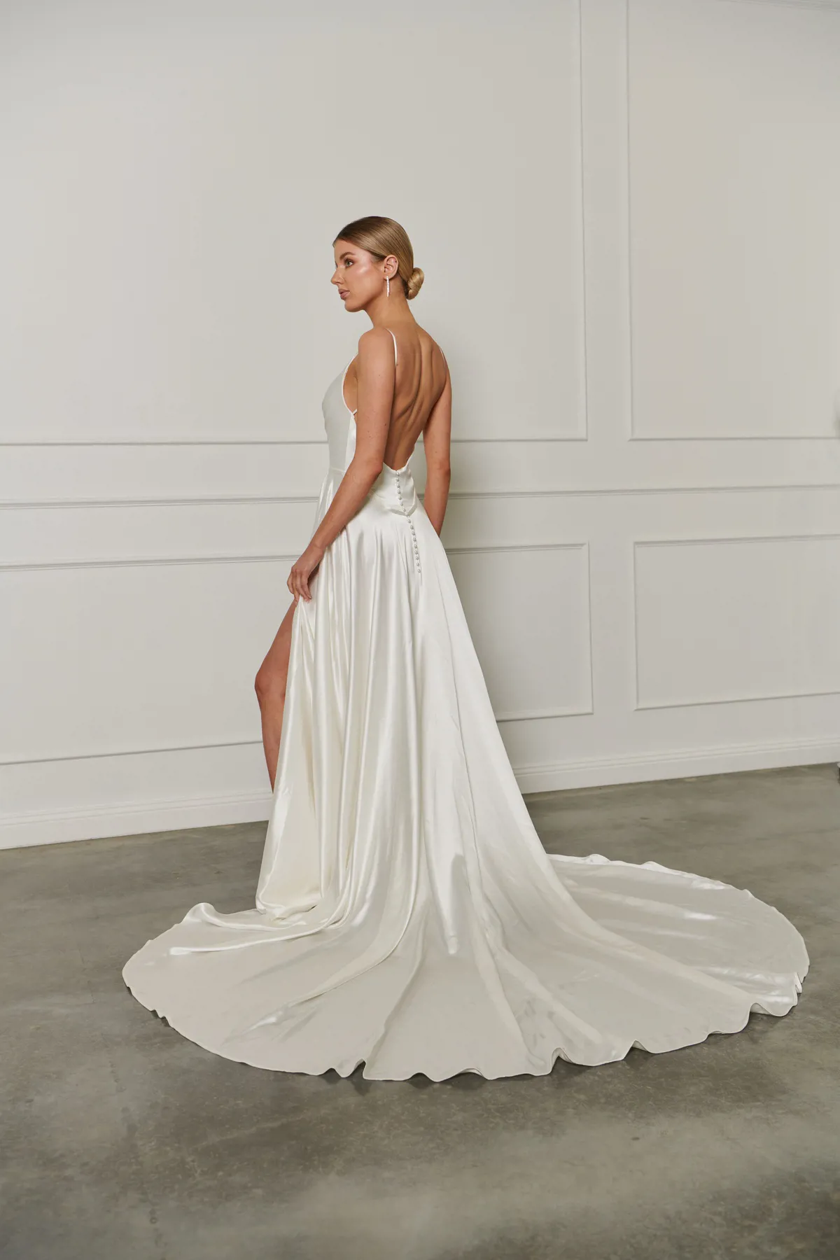 Satijnen trouwjurk 23207 van Cizzy Bridal met lage rug en split. Achteraanzicht van de A-lijn jurk met picpac knoopjes.