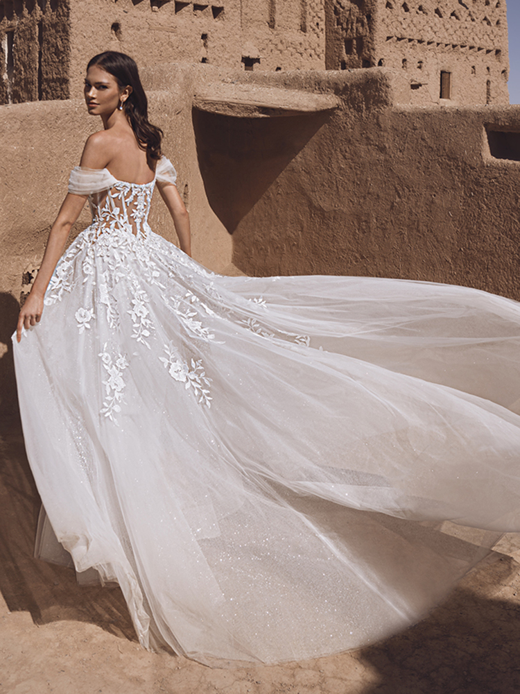 A-lijn trouwjurk Taylee van Blue by Enzoani met off-shoulder bandjes. Achteraanzicht van het see-through korset en glitter tule.