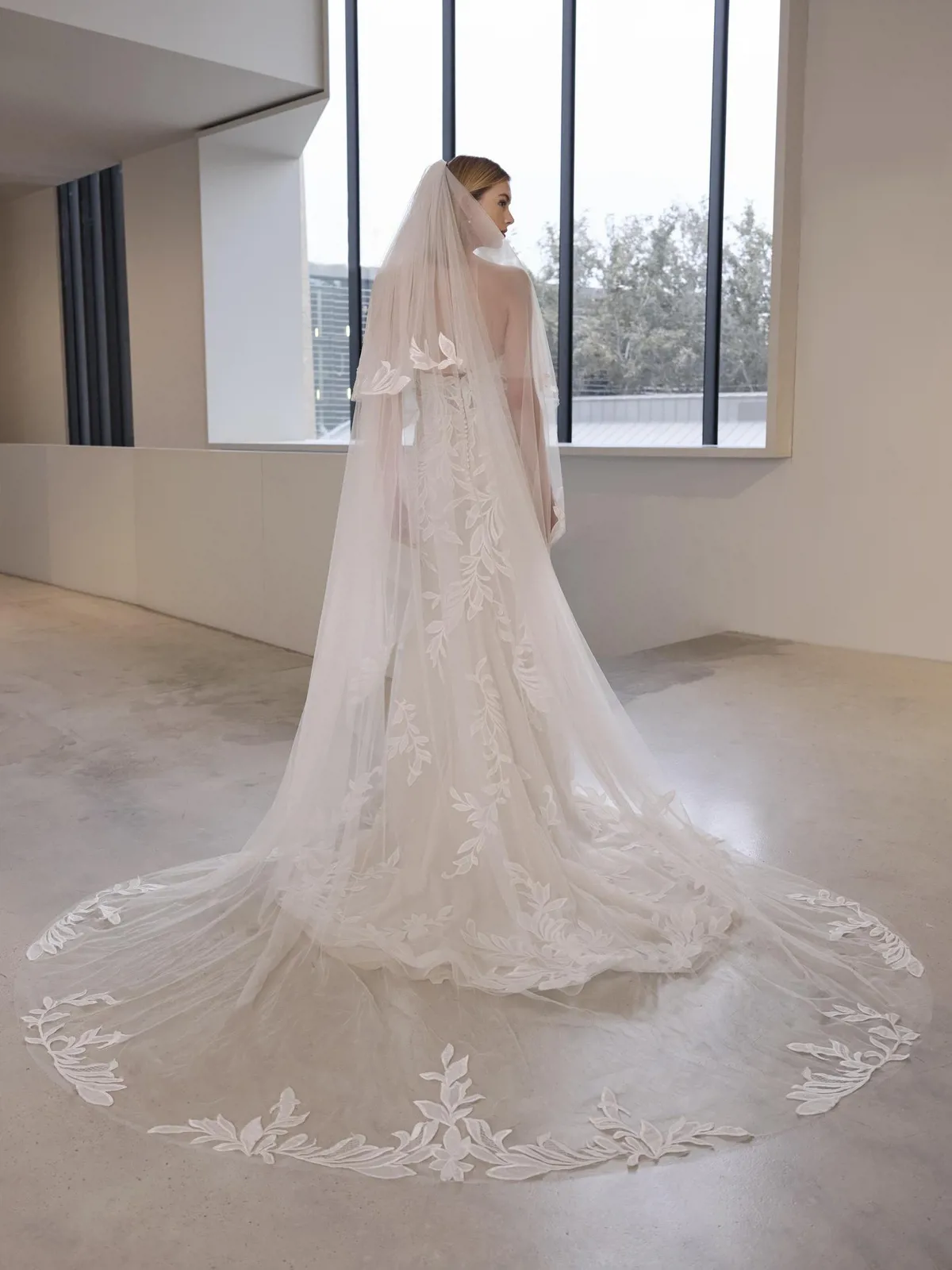 Trouwjurk Debie van Pronovias, achteraanzicht met lange sleep van botanisch kant en picpac knoopjes.