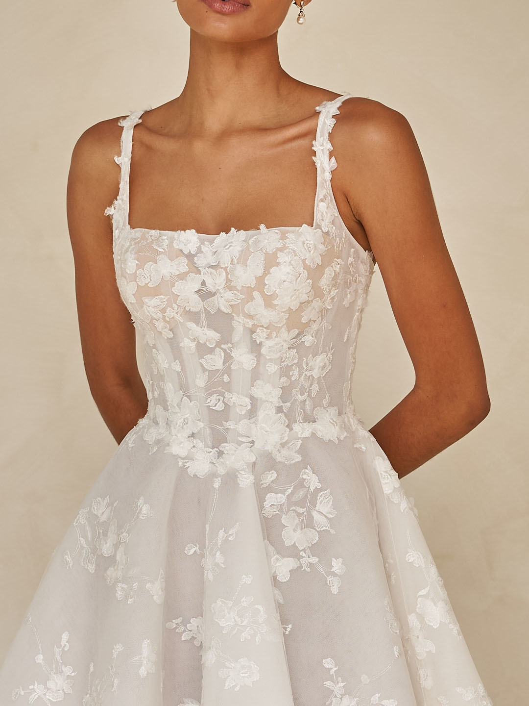 Trouwjurk met 3D kant WAVERLY van Ines di Santo, close-up van het korsetlijfje met schouderbandjes en vierkante hals.