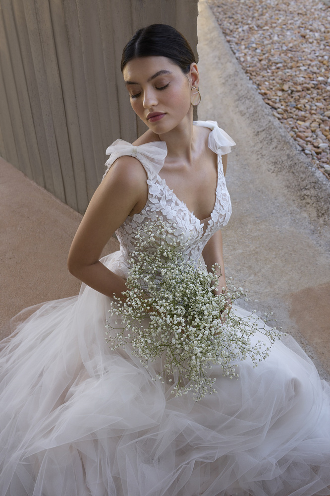 A-lijn trouwjurk met kant L1178 van Orea sposa met flowy tule rok. Close-up van het lijfje met V-hals en schouderstrikjes.
