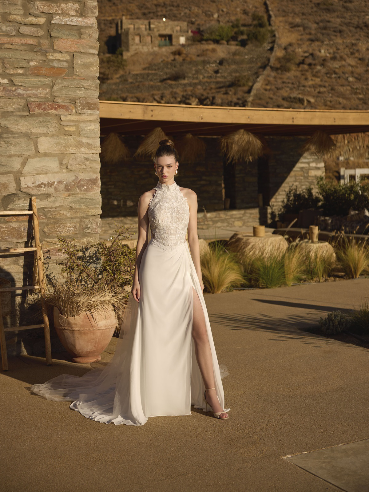 Trouwjurk met split Helmi van Modeca in vooraanzicht. Deze moderne bruidsjurk heeft een kanten lijfje en hoge halternek.