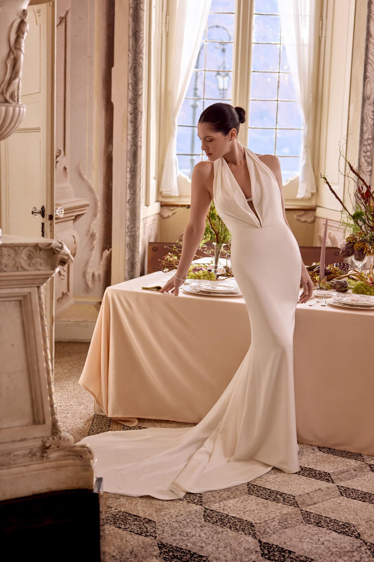 Trouwjurk zeemeermin 88465 van Justin Alexander. Zijaanzicht van minimalistische halterjurk met gedrapeerde diepe V-hals.