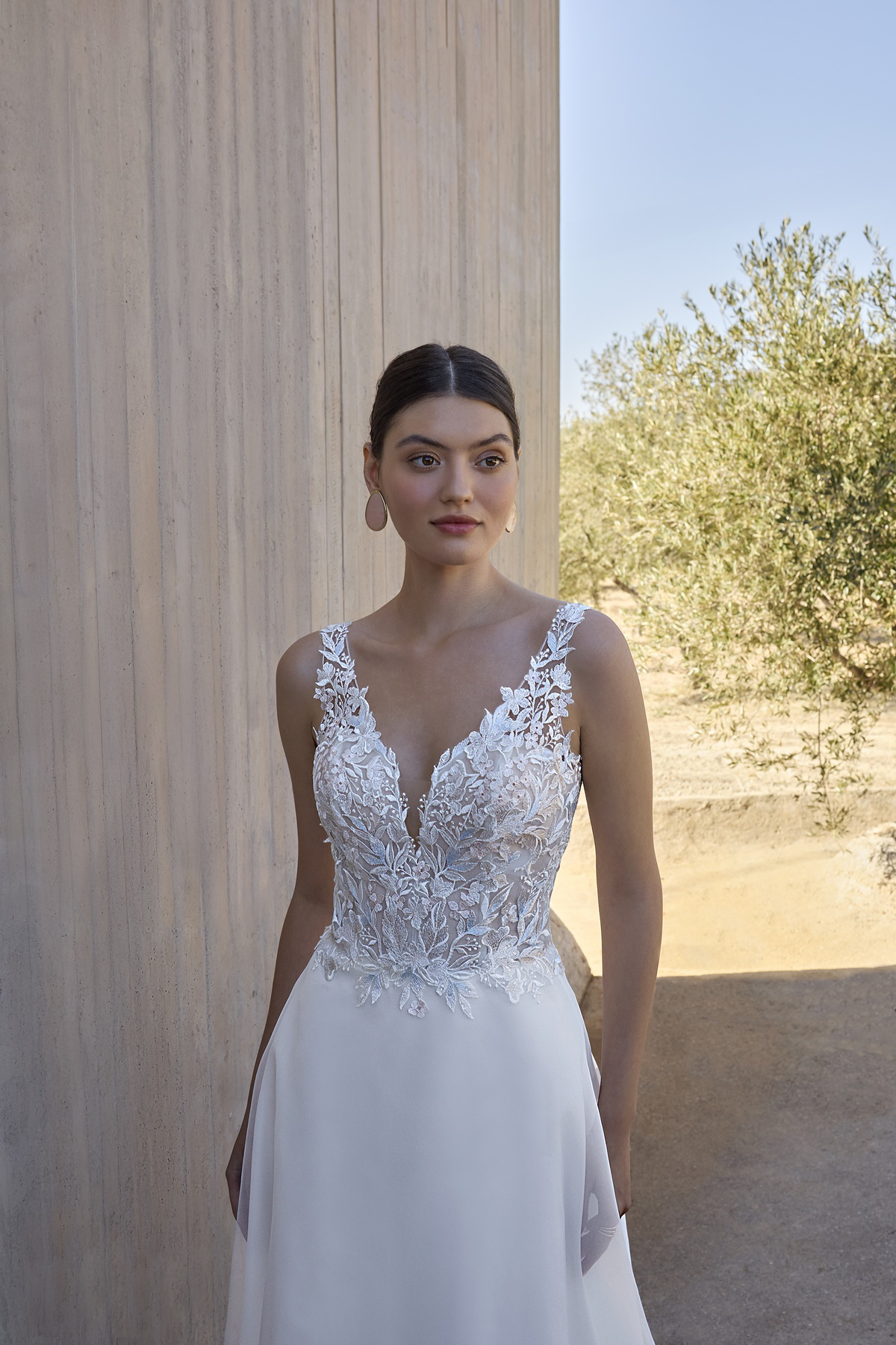 A-lijn trouwjurk L1174 van Orea sposa met V-hals. Close-up van het see-through lijfje met kanten bloemenapplicaties.