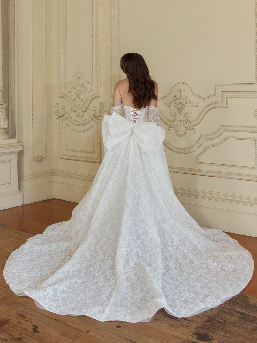 Trouwjurk met grote strik Vivonne van Jeune by Madi Lane. Achteraanzicht van de kanten jurk met vetering en lange sleep.