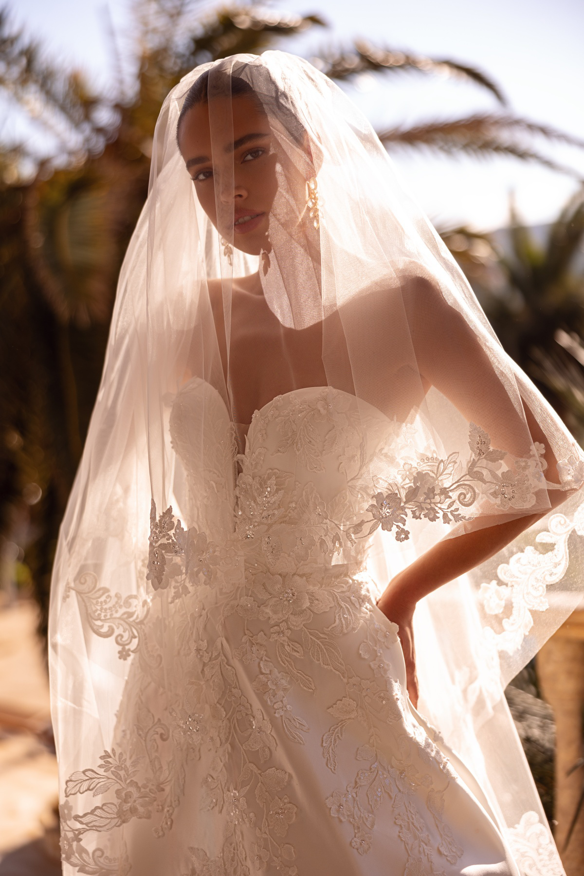 Bruidsjurk met kant 8255 van Cosmobella. Close-up van het strapless sweetheart lijfje, gezien door de kanten sluier.