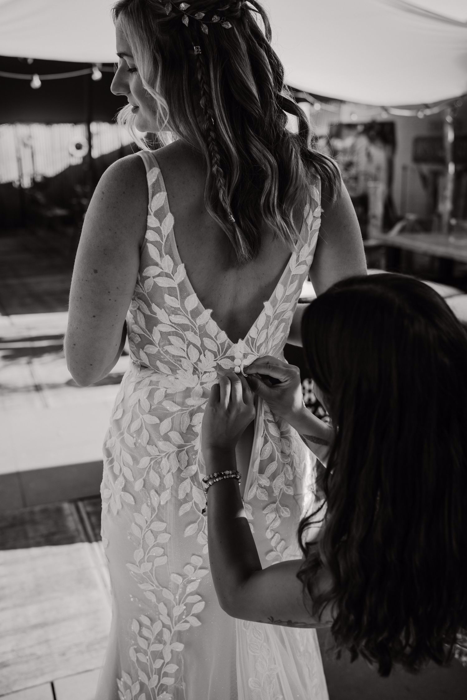 Real bride Lisa van Dooren tijdens het aankleden, in een romantische fit & flare jurk met open rug en bladkant.