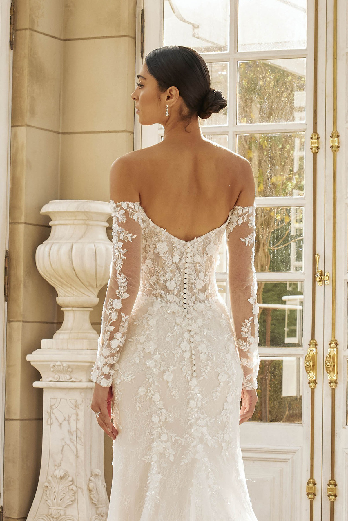 Off-shoulder trouwjurk Hartford van Jeune by Madi Lane. Achteraanzicht van de lage rug met 3D kant en lange mouwen.