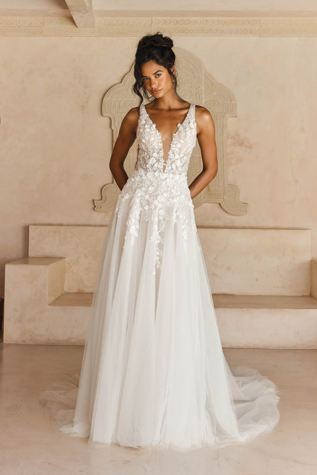 A-lijn trouwjurk Lyndall van Madi Lane met diepe V-hals en 3D bloemenkant. Vooraanzicht met een flowy tule rok.