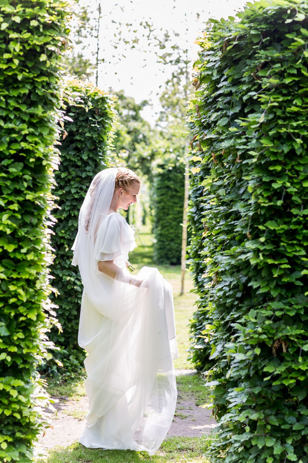 Nienke in trouwjurk tussen de bosjes