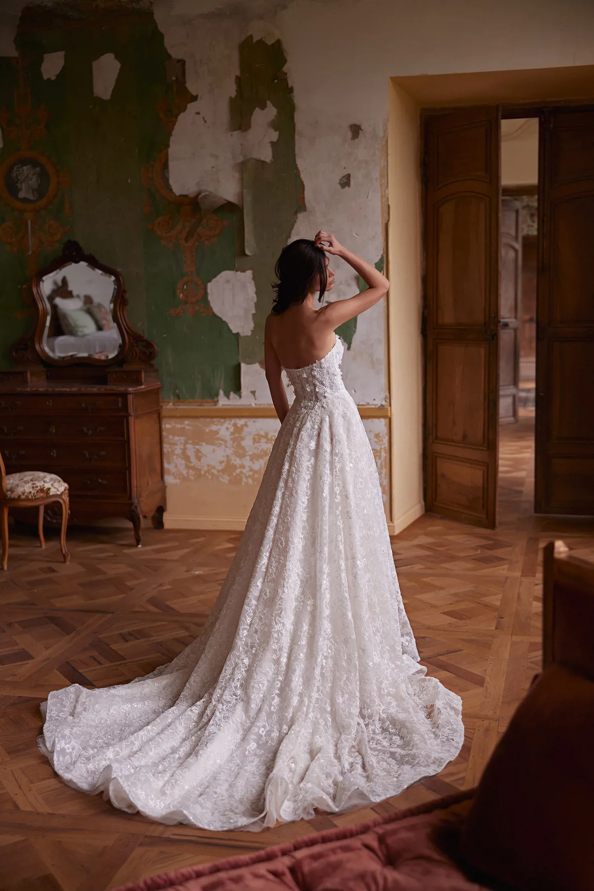 A-lijn trouwjurk Sybil van Pronovias, achteraanzicht. De strapless bruidsjurk is volledig van kant met een lange sleep.