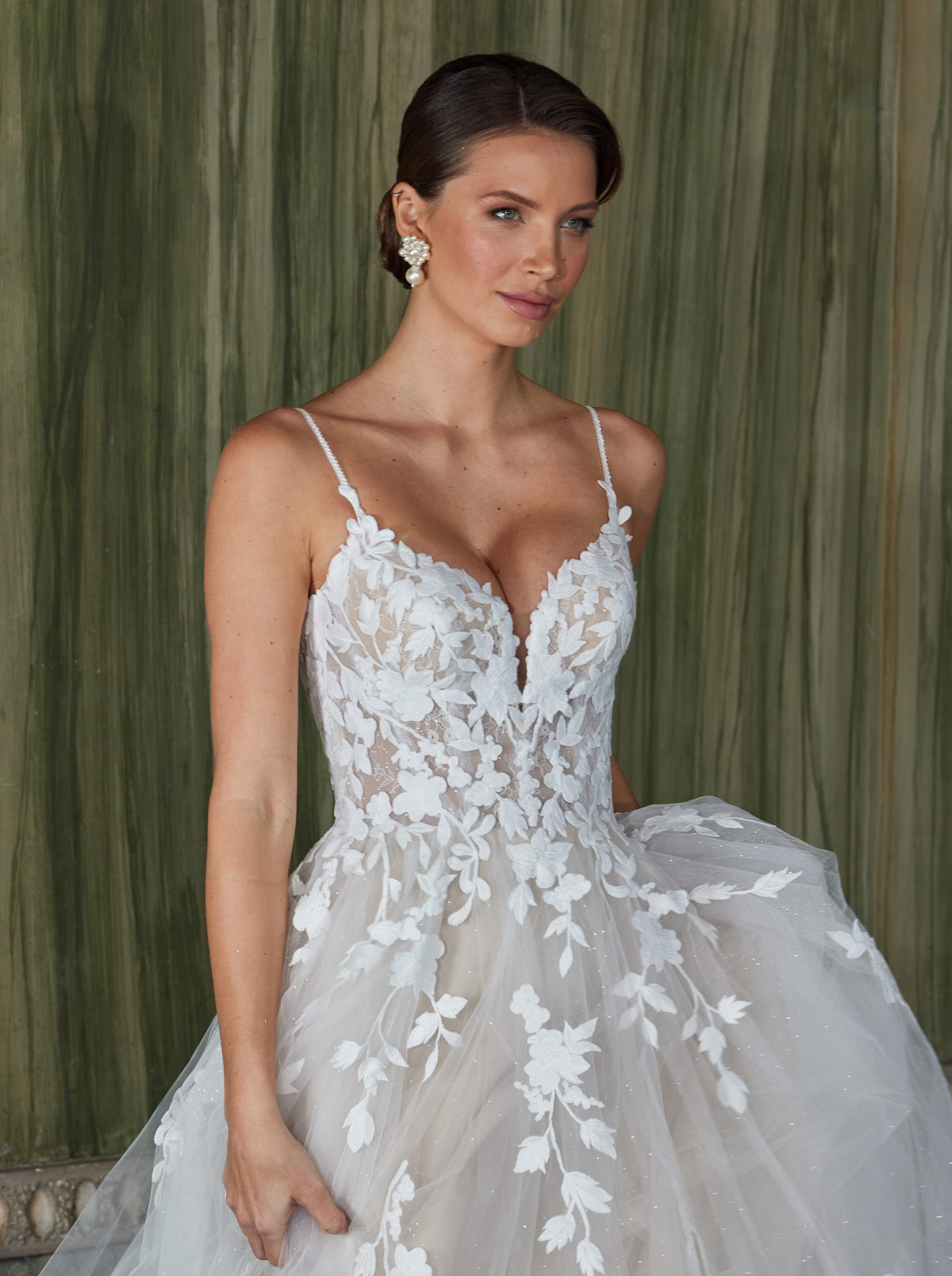 Trouwjurk met V-hals 50921 van Diane Legrand. Close-up van het kanten lijfje met see-through details en glitter tule.