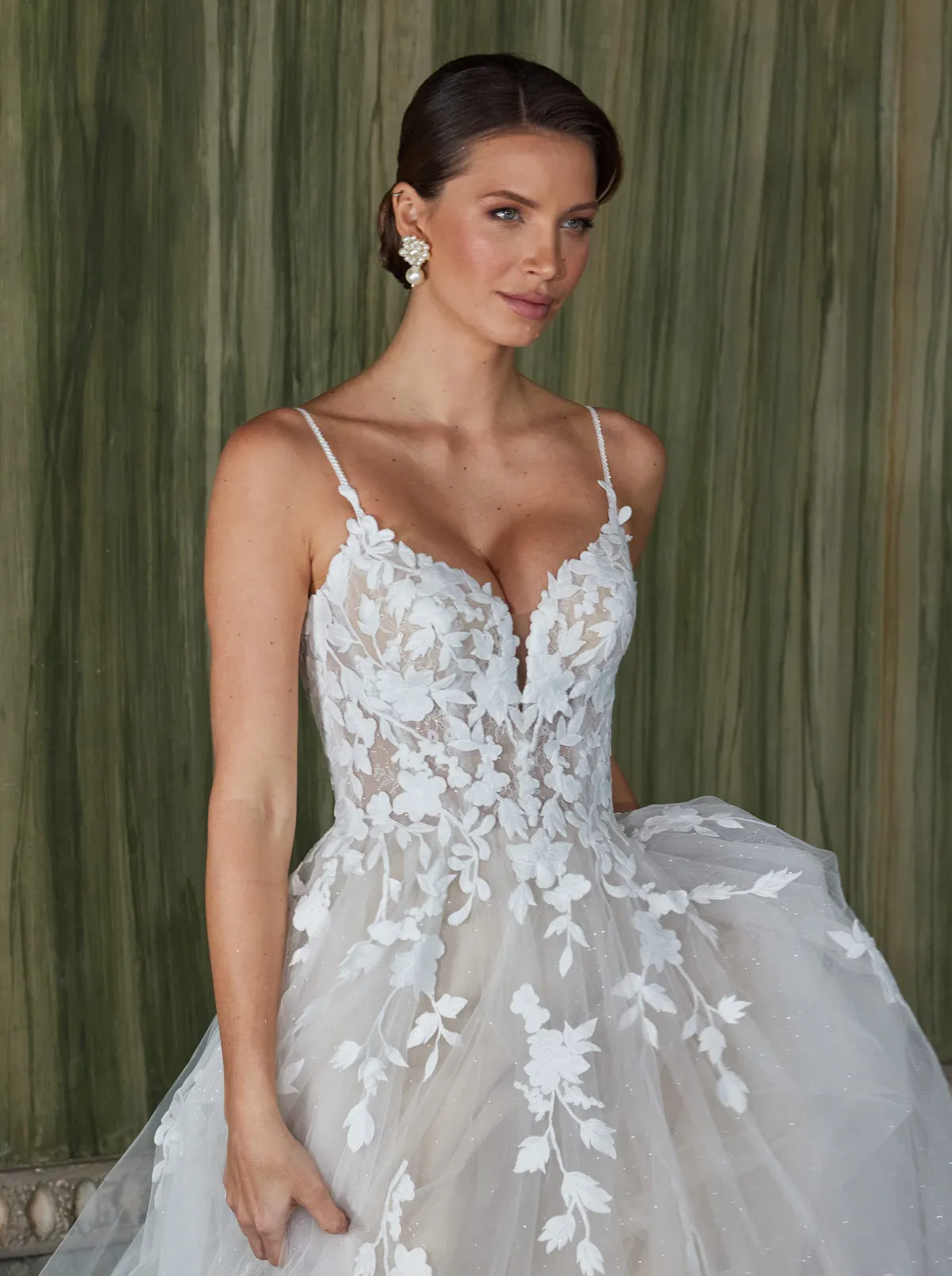 Trouwjurk met V-hals 50921 van Diane Legrand. Close-up van het kanten lijfje met see-through details en glitter tule.