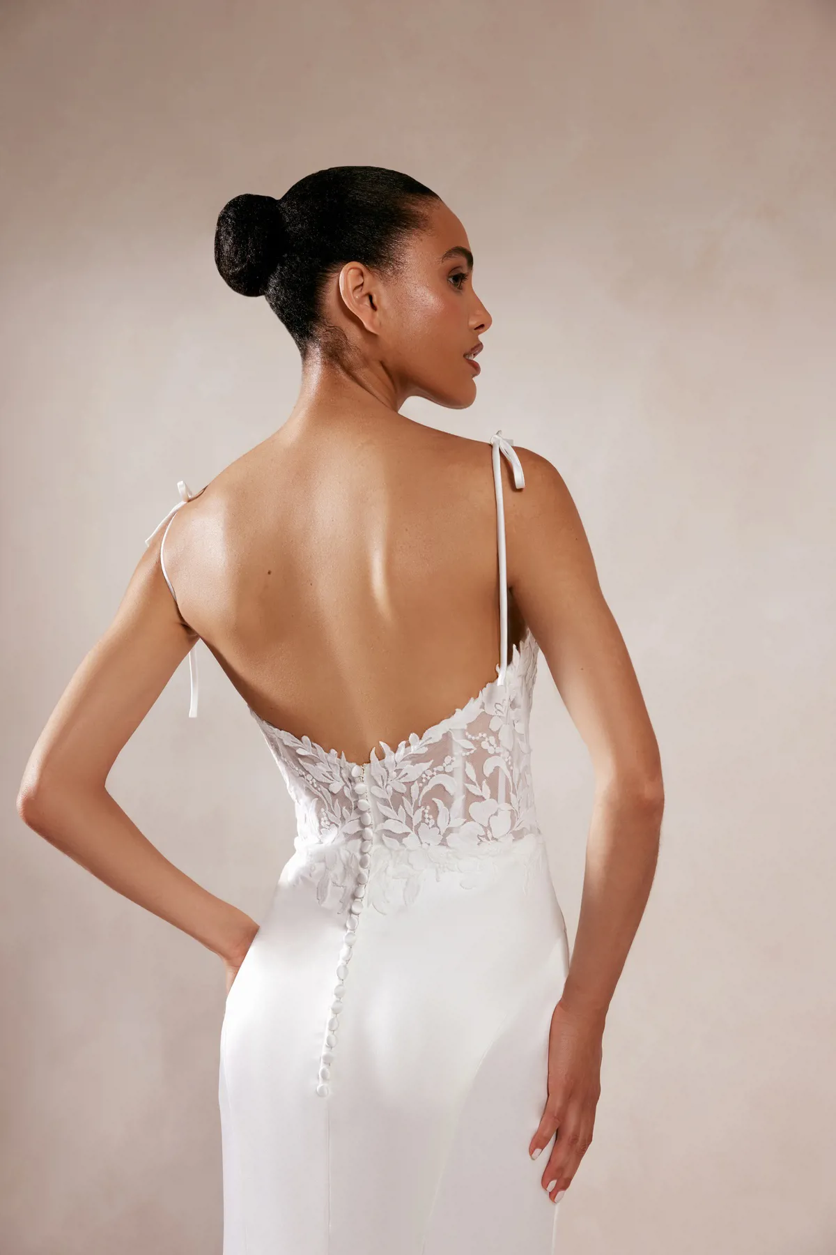 Trouwjurk met lage rug Akemi van Adore. Achteraanzicht van het kanten see-through lijfje met picpac knoopjes op de rok.