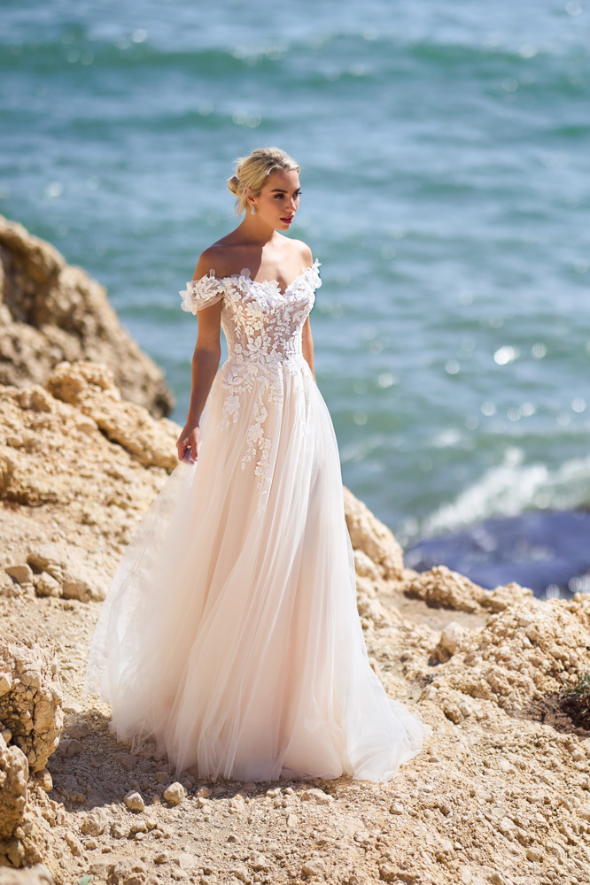 A-lijn trouwjurk 26112 van Tres chic met romantisch off-shoulder lijfje van kant en een flowy tule rok. Vooraanzicht.