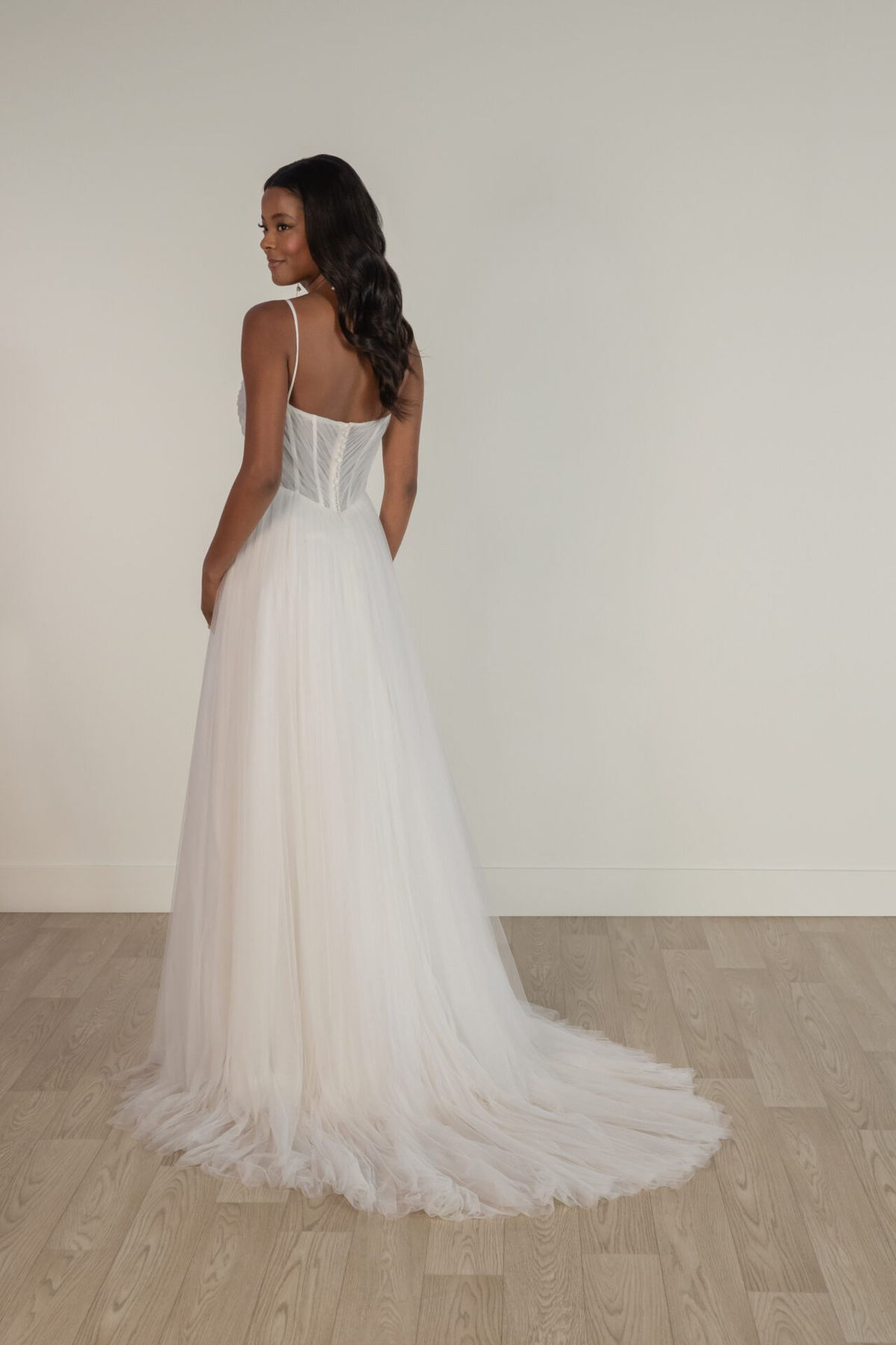 A-lijn trouwjurk 8113 Stella York achteraanzicht. See-through korsetlijfje met baleinen en dromerige tule rok met sleep.