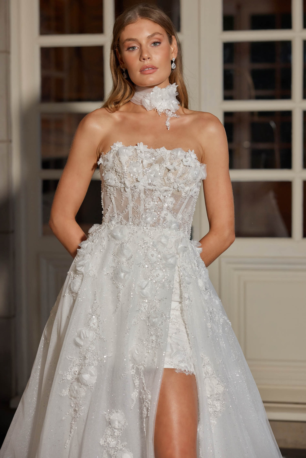 Trouwjurk met overrok Soho van Jeune by Madi Lane. Vooraanzicht van het strapless korsetlijfje en split. Exclusief bij Bruidshuis Diana.