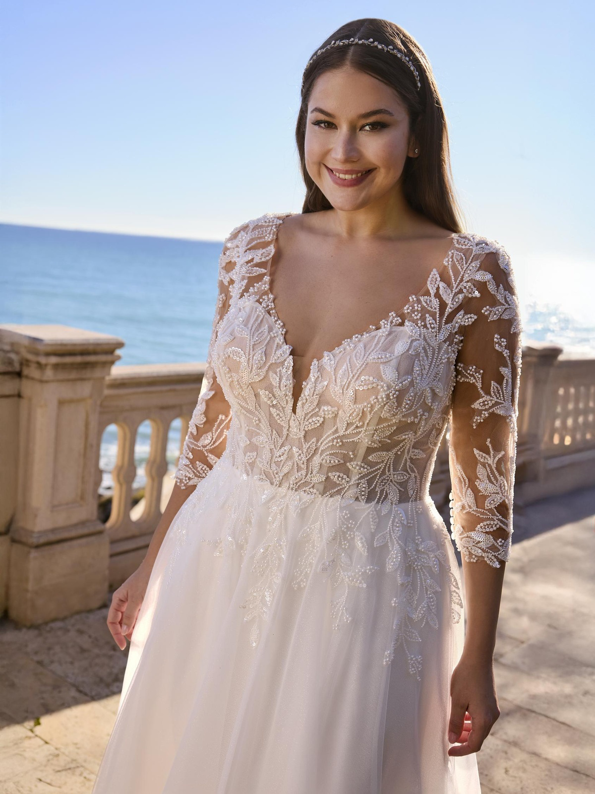 Trouwjurk met lange mouwen Syringa van Ladybird. Close-up van het see-through lijfje met V-hals en kanten bladmotief.