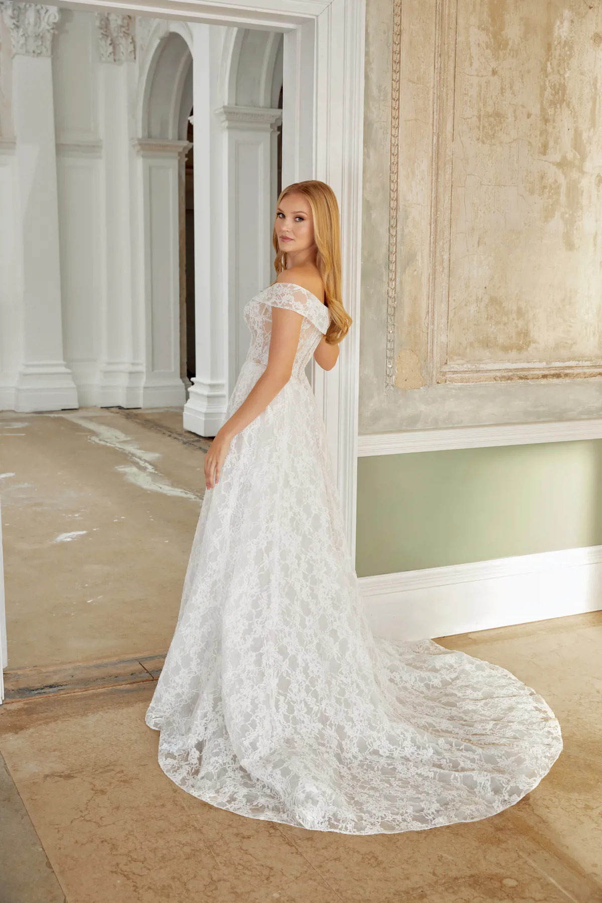 Trouwjurk met kant 44541 van Sincerity Bridal. Romantische A-lijn met off-shoulder halslijn, achteraanzicht met sleep.