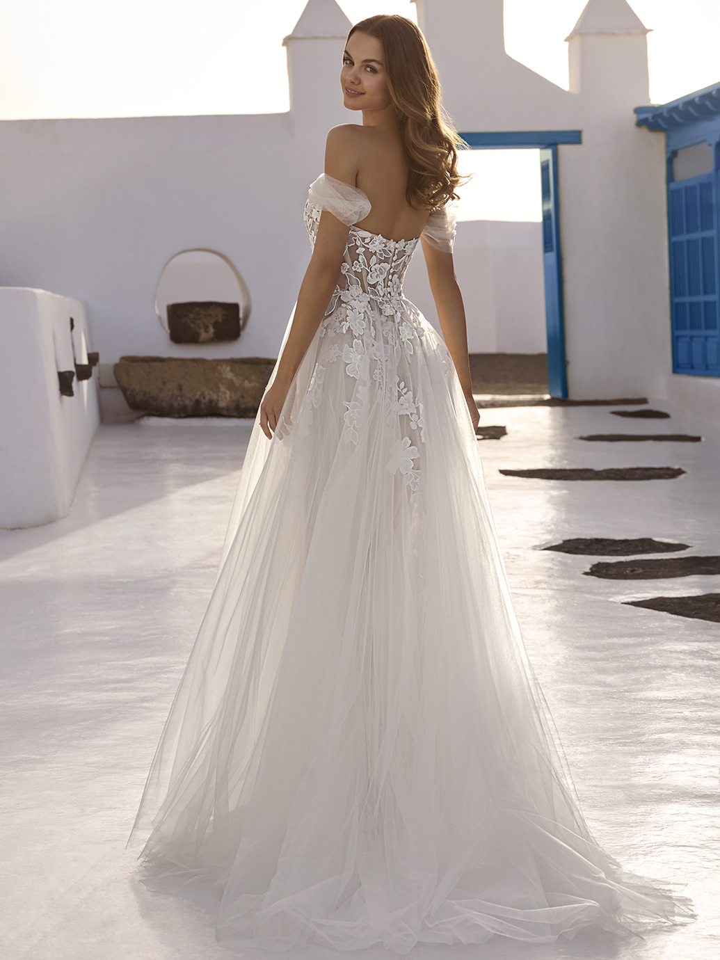 A-lijn trouwjurk Enola van Love by Enzoani, achteraanzicht met off-shoulder bandjes en een see-through kanten lijfje.