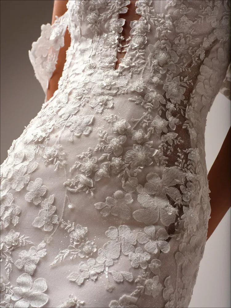 Trouwjurk met 3D kant Malone van Maggie Sottero. Close-up van het see-through lijfje met bloemenapplicaties en glitter.