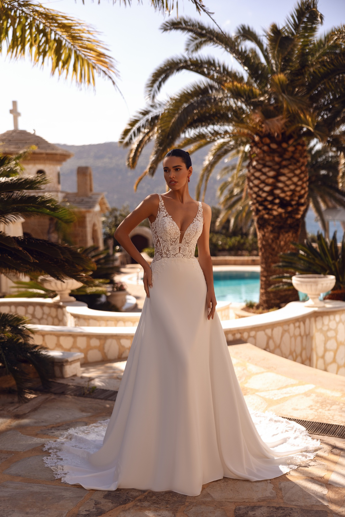 A-lijn trouwjurk 8258 van Cosmobella met een kanten lijfje met V-hals en een gladde rok. Vooraanzicht van de jurk.