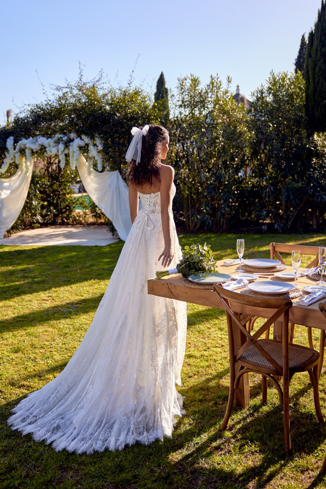 A-lijn trouwjurk met kant 66432 van Lillian West. Achteraanzicht van het strapless korsetlijfje en de lange sleep.