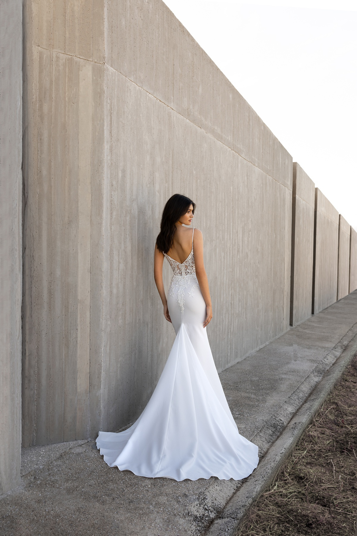 Zeemeermin trouwjurk L1170 van Orea sposa. Achteraanzicht van de jurk met een lage rug met kant en een lange, gladde sleep.