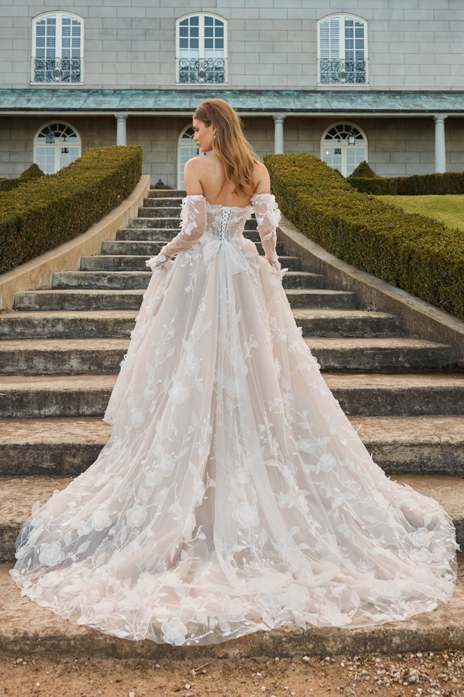 A-lijn trouwjurk Juno van Jeune by Madi Lane, achteraanzicht met korsetlijfje en 3D bloemen.