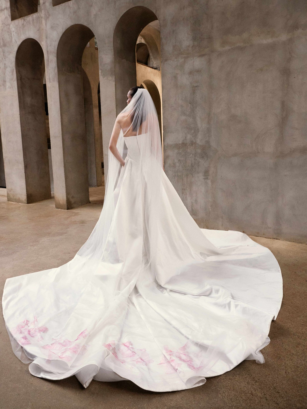 Strapless A-lijn trouwjurk Dynasty van Galia Lahav. Achteraanzicht van de jurk met lange sleep en roze bloemenprint.