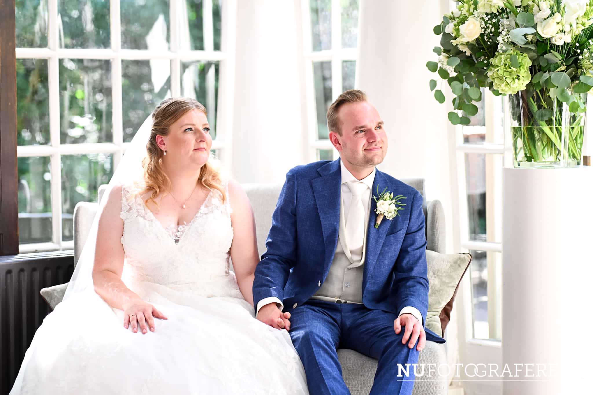 Bruid Stefanie Hegelsom poseert samen met haar bruidegom in een bosrijke omgeving en draagt een romantische trouwjurk met sluier van Bruidshuis Diana